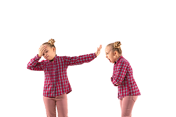 Image showing Young handsome girl arguing with herself on white studio background.