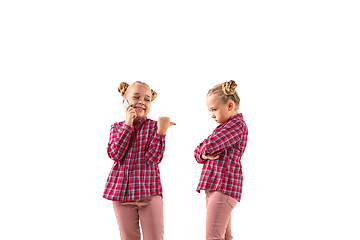 Image showing Young handsome girl arguing with herself on white studio background.