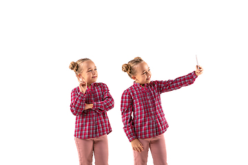 Image showing Young handsome girl arguing with herself on white studio background.