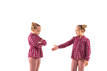 Image showing Young handsome girl arguing with herself on white studio background.