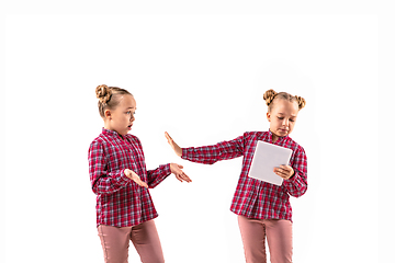 Image showing Young handsome girl arguing with herself on white studio background.