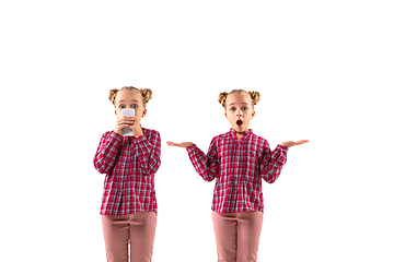 Image showing Young handsome girl arguing with herself on white studio background.