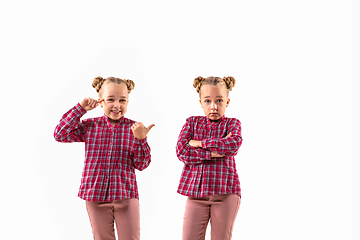 Image showing Young handsome girl arguing with herself on white studio background.