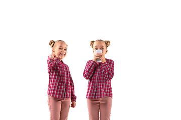 Image showing Young handsome girl arguing with herself on white studio background.