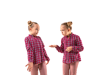 Image showing Young handsome girl arguing with herself on white studio background.