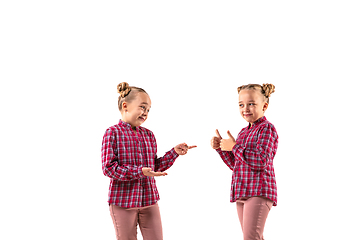 Image showing Young handsome girl arguing with herself on white studio background.