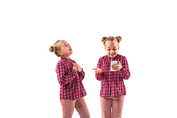 Image showing Young handsome girl arguing with herself on white studio background.