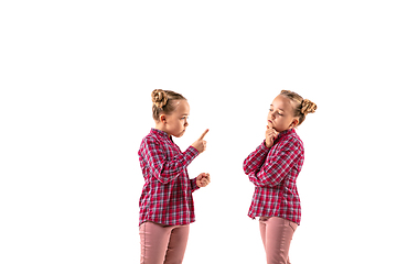 Image showing Young handsome girl arguing with herself on white studio background.