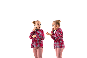 Image showing Young handsome girl arguing with herself on white studio background.