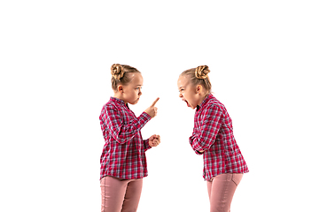 Image showing Young handsome girl arguing with herself on white studio background.