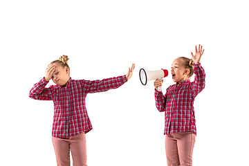 Image showing Young handsome girl arguing with herself on white studio background.