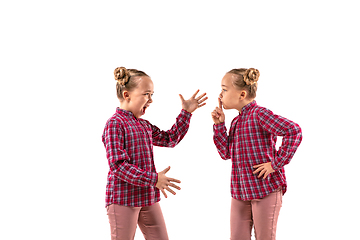 Image showing Young handsome girl arguing with herself on white studio background.