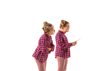 Image showing Young handsome girl arguing with herself on white studio background.