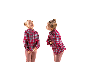 Image showing Young handsome girl arguing with herself on white studio background.