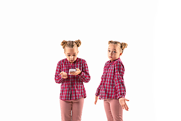 Image showing Young handsome girl arguing with herself on white studio background.