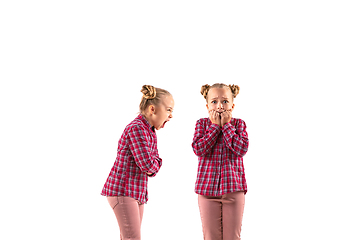 Image showing Young handsome girl arguing with herself on white studio background.