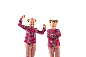 Image showing Young handsome girl arguing with herself on white studio background.