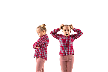 Image showing Young handsome girl arguing with herself on white studio background.