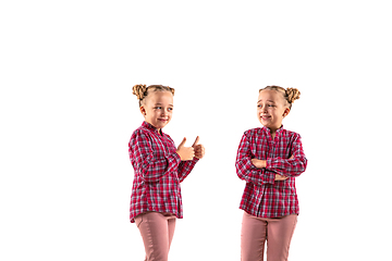 Image showing Young handsome girl arguing with herself on white studio background.