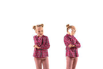 Image showing Young handsome girl arguing with herself on white studio background.