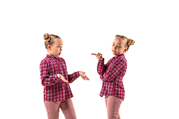 Image showing Young handsome girl arguing with herself on white studio background.