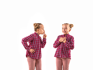 Image showing Young handsome girl arguing with herself on white studio background.