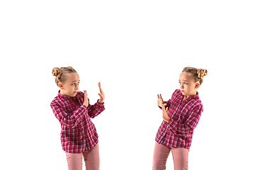 Image showing Young handsome girl arguing with herself on white studio background.