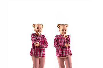 Image showing Young handsome girl arguing with herself on white studio background.