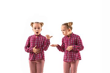 Image showing Young handsome girl arguing with herself on white studio background.