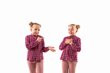 Image showing Young handsome girl arguing with herself on white studio background.