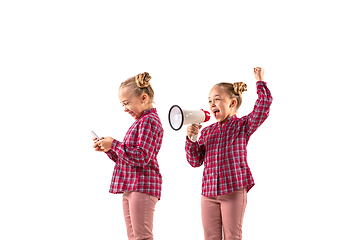 Image showing Young handsome girl arguing with herself on white studio background.