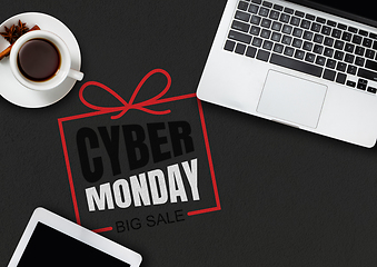 Image showing Top view of laptop and cup of tea with cyber monday lettering on black background
