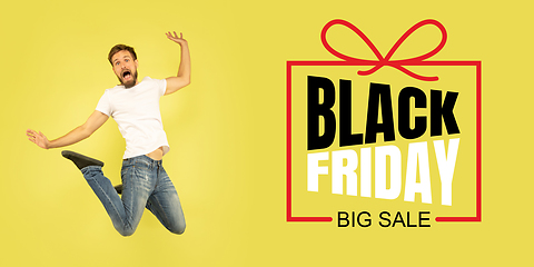 Image showing Portrait of young man on yellow background with black friday lettering