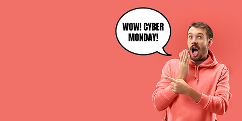 Image showing Half-length close up portrait of young man on coral background with cuber monday lettering