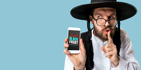 Image showing Portrait of young man showing smartphone screen, black friday