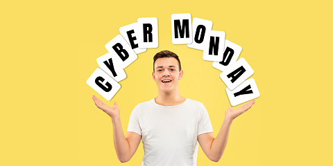 Image showing Half-length close up portrait of young man on yellow background with cuber monday lettering