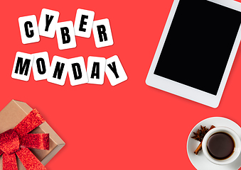 Image showing Top view of tablet and present, gift with cyber monday lettering on red background