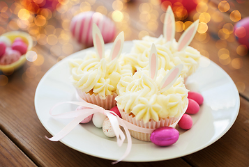 Image showing cupcakes with easter eggs and candies on table