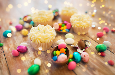 Image showing cupcakes with chocolate eggs and candies on table