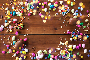 Image showing chocolate eggs and candy drops on wooden table