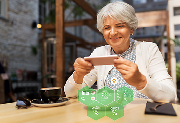 Image showing old woman with smartphone and food at restaurant