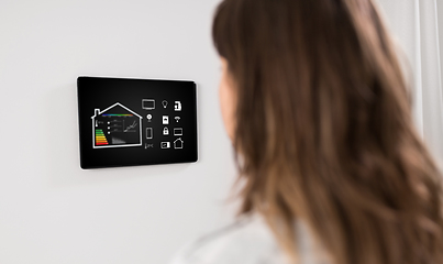 Image showing woman looking at tablet computer at smart home