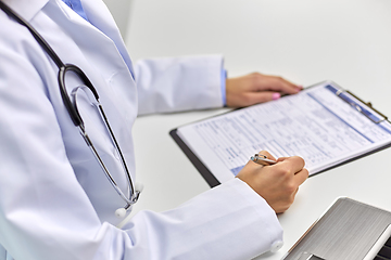 Image showing close up of female doctor writing medical report