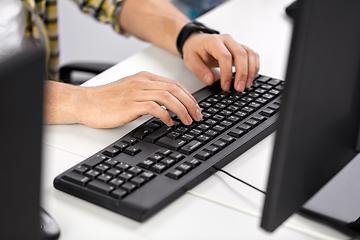 Image showing male hands typing on computer keyboard on table