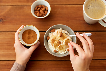 Image showing hands with oatmeal breakfast and cup of coffee