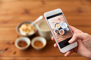 Image showing hand taking picture of breakfast with smartphone