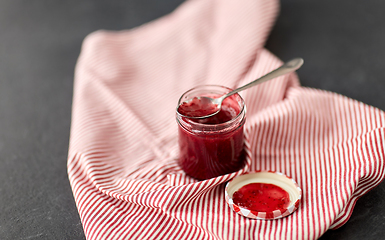 Image showing mason jar with raspberry jam and spoon on towel