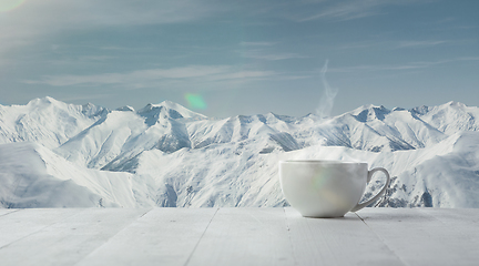 Image showing Single tea or coffee cup and landscape of mountains on background