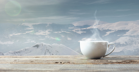 Image showing Single tea or coffee cup and landscape of mountains on background