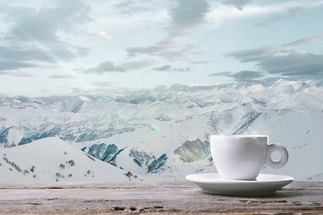 Image showing Single tea or coffee cup and landscape of mountains on background